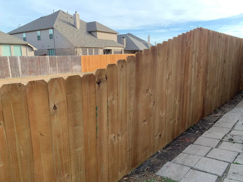 Stained wood fence along a residential yard.
